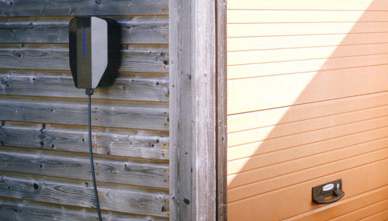 Laddbox monterad på vägg vid en garagelänga
